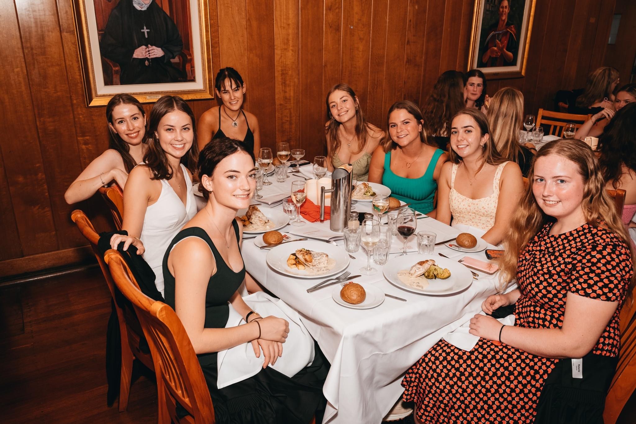Country Education Foundation of Australia alumnus, Josie Kearney, seated at the head of the table, enjoys a meal with fellow students at Sancta Sophia College.