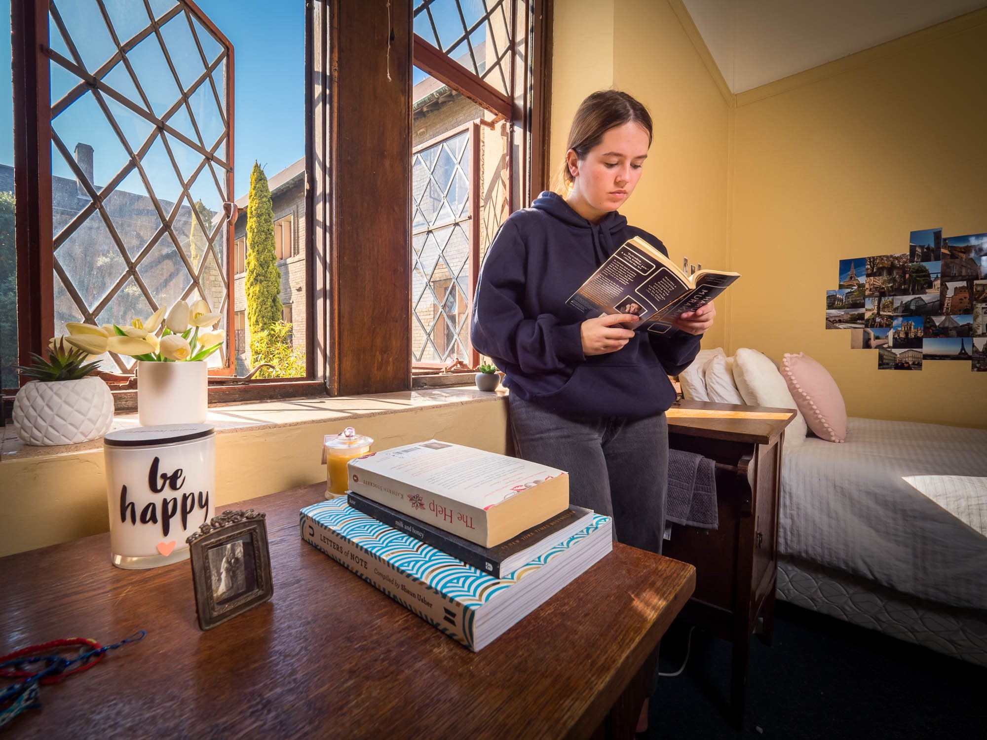 A Sancta Sophia College student reads near her room window.