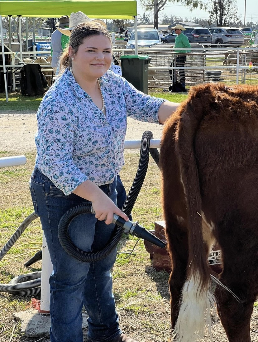 Caitlyn Coutts-Smith hoses down a cow.